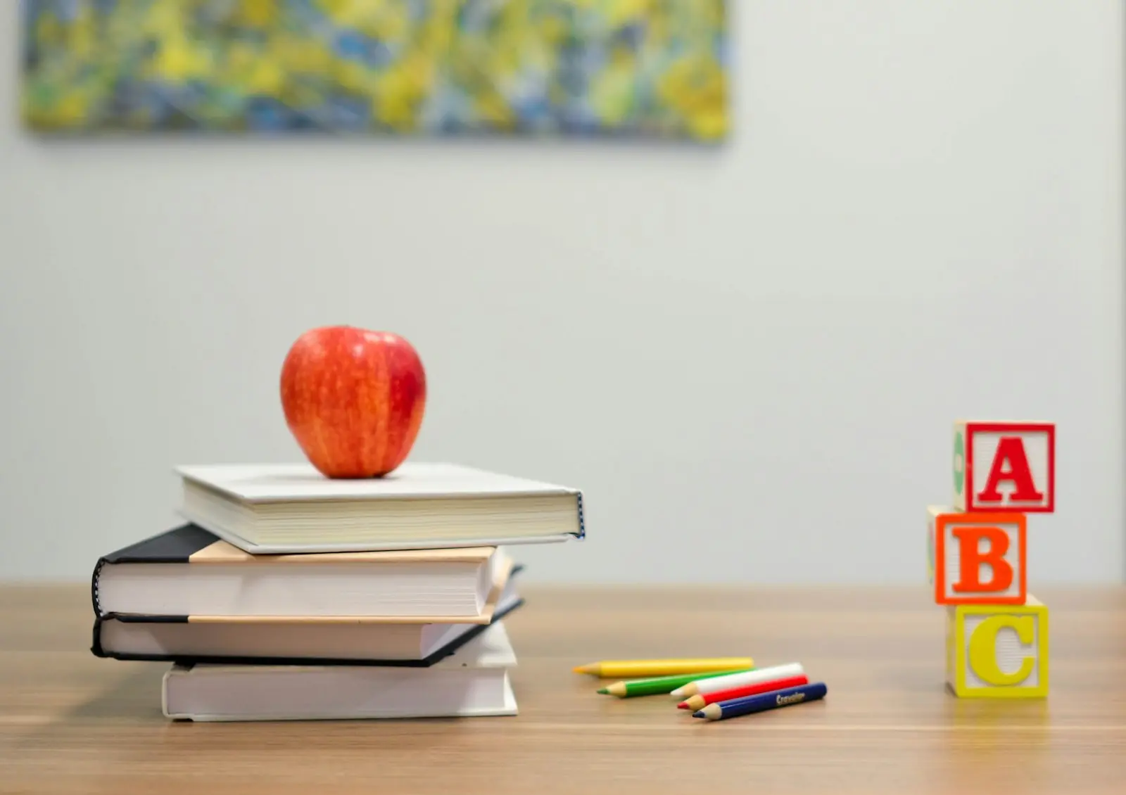 Desk with books, an apple and alphabet blocks