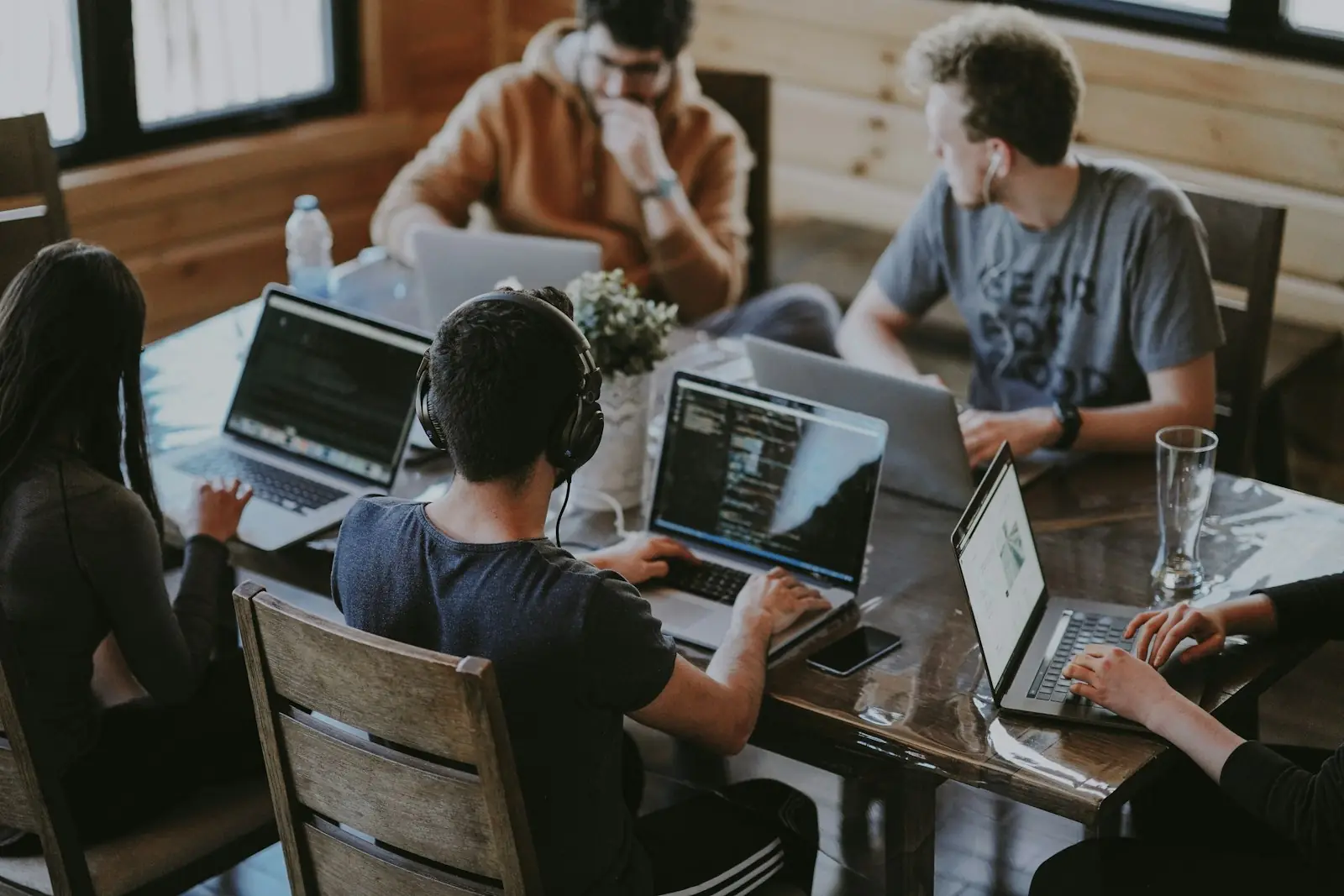 Young professionals collaborating around laptops