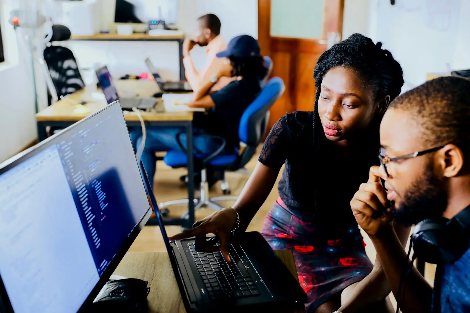 Two colleagues reviewing work on a laptop